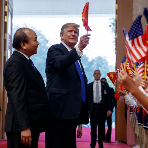 President Donald Trump waves a Vietnam flag...