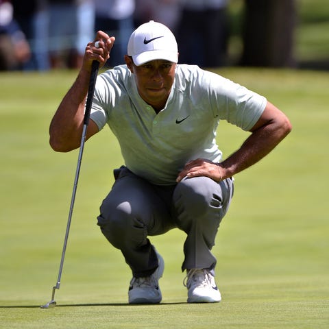 Tiger Woods lines up a putt on the third green...
