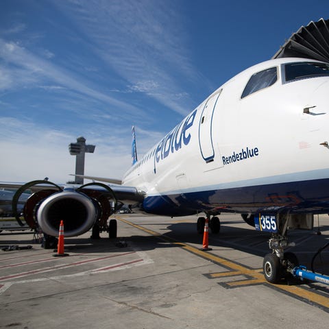 A JetBlue Embraer E190 gets some work after an...