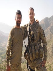 Interpreter Nabi Mohammadi, left, stands with Iowa National Guard Lt. Pat Hendrickson in Afghanistan during the Iowa Guard's 2010-11 deployment there.
