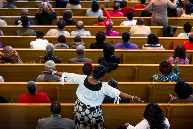 A congregant raises her arms during the 7:30 a.m. service on Feb. 24, 2019, at Pilgrim Rest Baptist Church in Phoenix. Pastor Terry Mackey was appointed to replace the late Bishop Alexis Thomas.