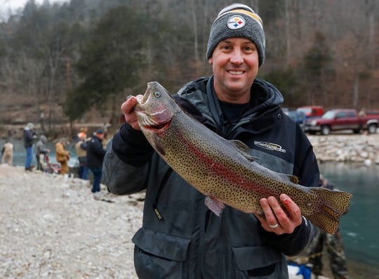 Mike Luttrell holds up the 6.65 pound rainbow trout he caught during opening day of trout season at Roaring River State Park on Friday, Mar. 1, 2019.