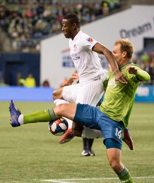 FC Cincinnati forward Fanendo Adi (9) is guarded by Seattle Sounders defender Chad Marshall (14) during the first half at CenturyLink Field.