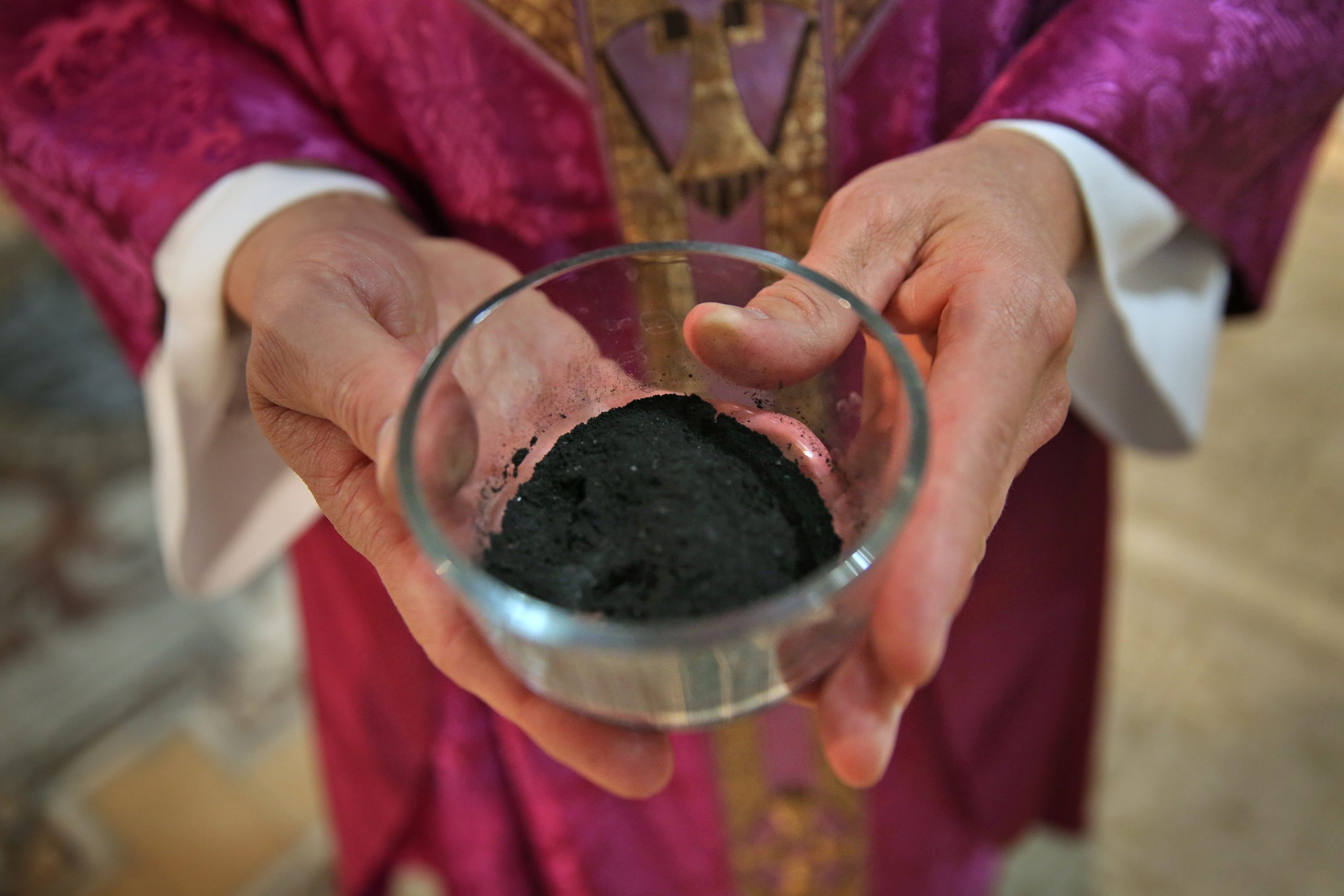 Father Rick Nagel shows the ashes used during Ash Wednesday service at Saint John Catholic Church, Wednesday, February 10, 2016.