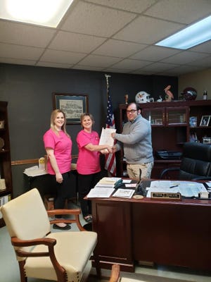 West Carroll Parish Registrar of Voters Kellie Drurey and Assistant Registrar Stephanie Boyte serve Oak Grove Mayor Adam Holland a petition signed by 347 qualified electors of the town of Oak Grove calling for an election to determine the sale and consumption of alcoholic beverages inside the city limits of Oak Grove.