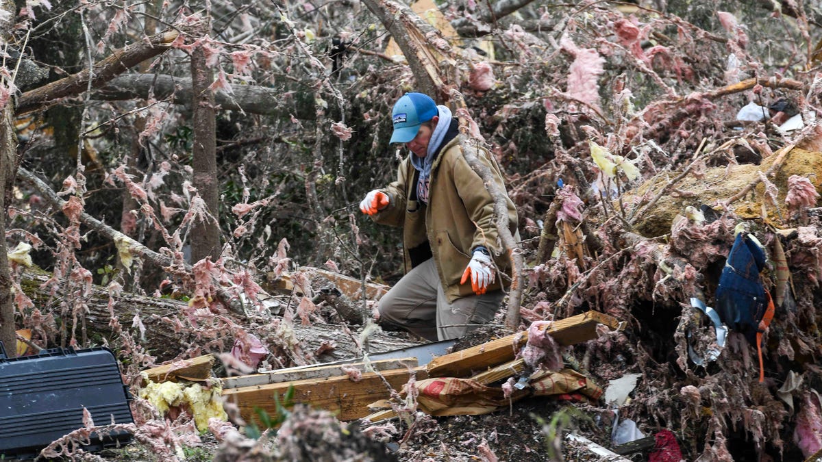 A resident looks through the debris of a family member's destroyed home the day after a deadly tornado ravaged the area, in Beauregard, Ala., March 4, 2019.