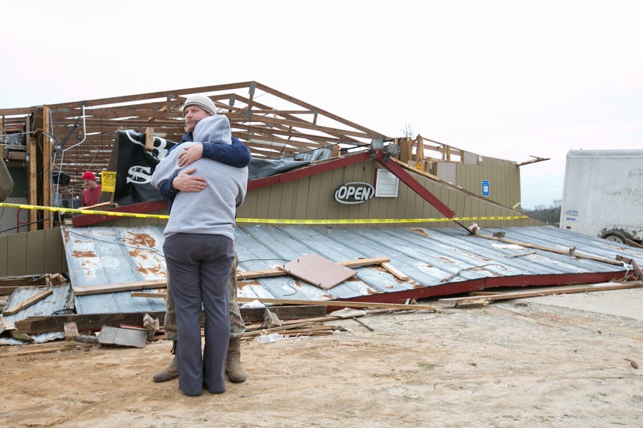 Gabe and Brandi O'Neal embrace outside of the Buck Wild Saloon after it was destroyed by a tornado March 4, 2019 in Smith Station, Ala.