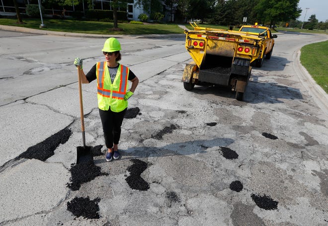Then gubernatorial candidate Gretchen Whitmer fills a pothole during a campaign event Aug. 6. in Southfield.