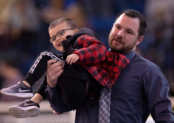 Cory Coble, Trigg County's basketball coach, returns his son, Owen, 4, to his mom after the youngster made a break between games at the 2019 Girls Region Tournament semifinals at Rocket Arena in Marion, Ky. Coble was named the new girls basketball coach at Union County on Friday.