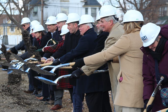 Richard Harding Sr., center right, in tan, tosses dirt into the air at a ground-breaking ceremony for the Warren G. Harding Presidential Center, what is expected to be a roughly 12,000-square-foot museum.