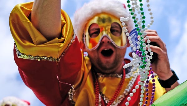 A float rider with the Krewe of Okeanos throws...