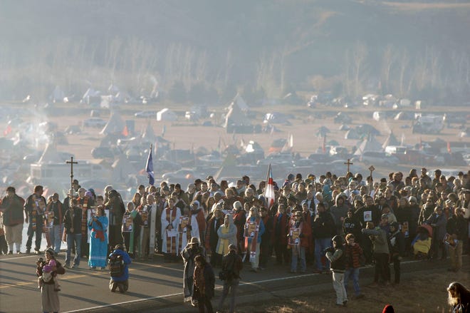 FILE - This Nov. 11, 2016 file photo shows more than 500 clergy from across the country gathered for a "Clergy for Standing Rock" march on N.D. Highway 1806 near Cannon Ball, N. D., from the Oceti Sakowin Camp to the Cantapeta Creek bridge to demonstrate their solidarity for the Dakota Access Pipeline protesters. South Dakota Gov. Kristi Noem says she's proposing legislation ahead of the Keystone XL oil pipeline's construction that would create a legal avenue to pursue out-of-state money that funds protests aimed at slowing construction. Noem's bills come after opponents of the Dakota Access oil pipeline staged large protests that resulted in 761 arrests in southern North Dakota over a six-month span beginning in late 2016. The state spent tens of millions of dollars policing the protests. (Mike McCleary/The Bismarck Tribune via AP, File)