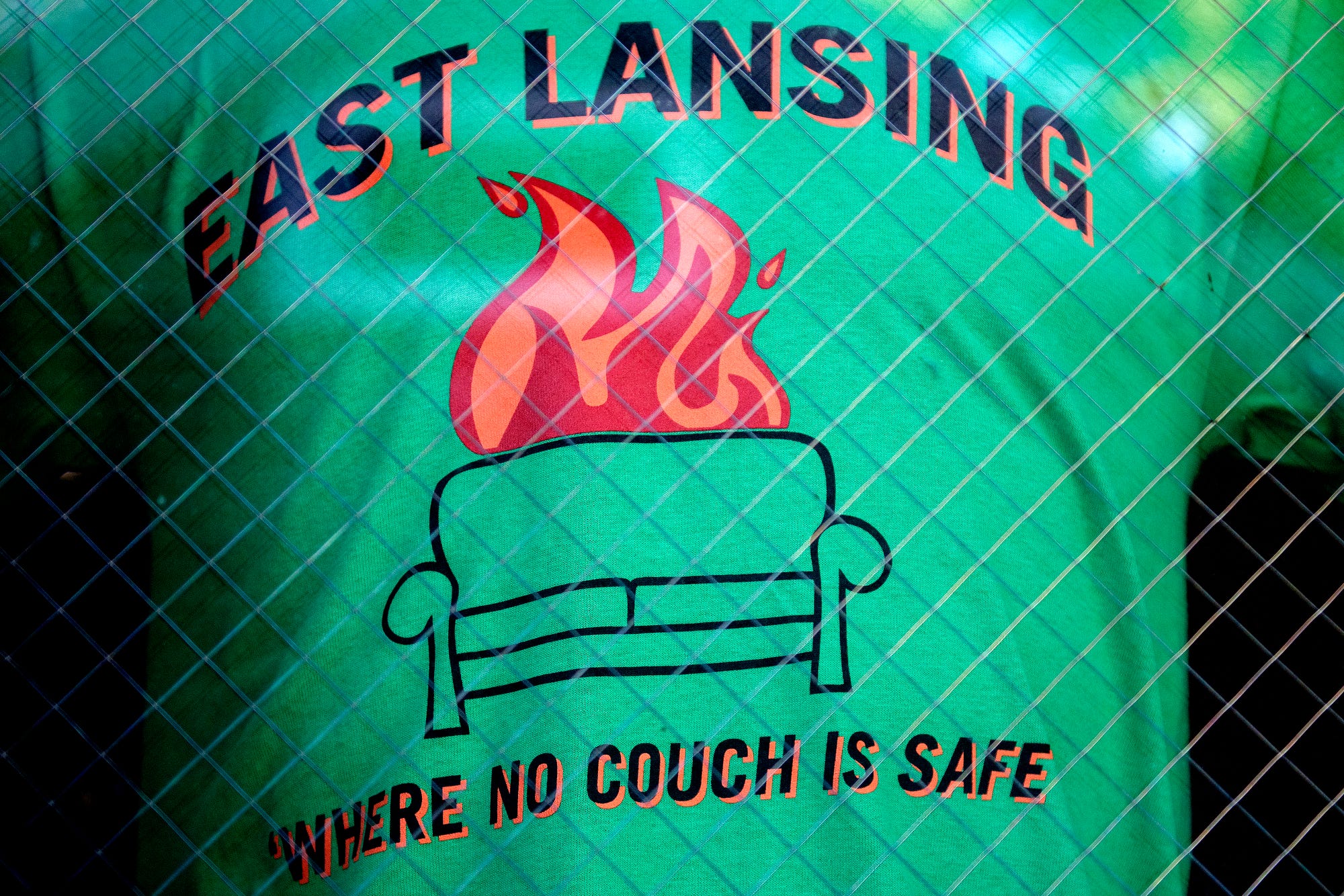 A shirt poking fun at East Lansing's history of couch burning is on display in the window at Campus Street Sportswear on Tuesday, Feb. 19, 2019, in downtown East Lansing.