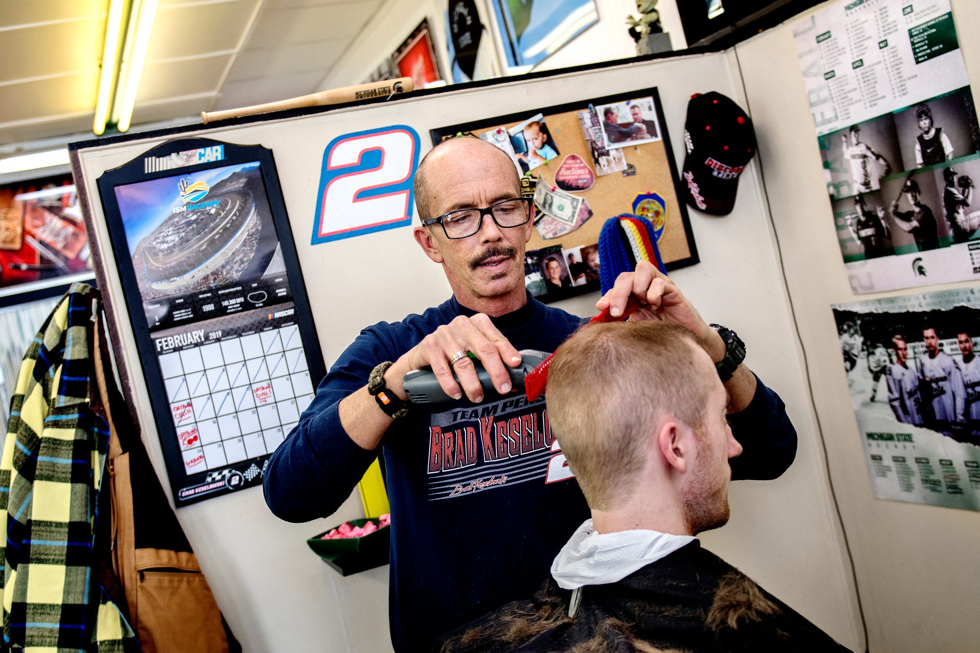 Jeff Cooper, co-owner of Campus Barbers, cuts a customer's hair on Thursday, Feb. 14, 2019, in East Lansing. Cooper was working in East Lansing at the time of the 1999 MSU riots and thinks a lot has changed since the incident.