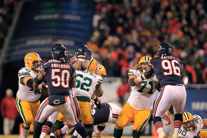 John Kuhn (30, on right) lays out after blocking Julius Peppers on a play that allowed Aaron Rodgers time to scramble and unload for a 48-yard touchdown in the final moments of the 2013 season.