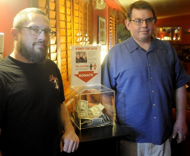 Phil Wooley (left) and David Mickelsen stand next to a donation box Wooley set up for Mickelsen at the Sagebrush Ranch in Mound House.