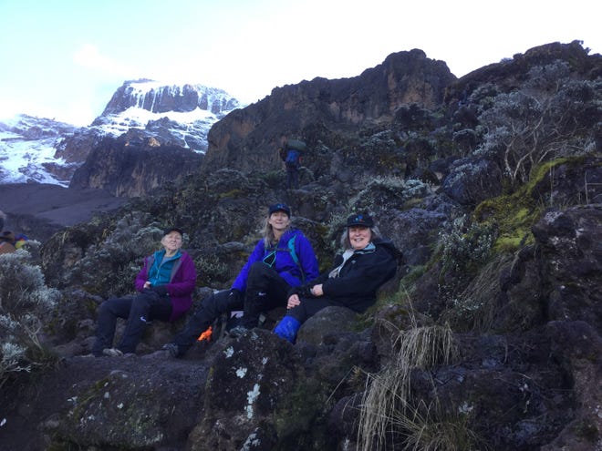 Betty Schley (left), Shaun Bennett (center) and Catherine Buick take a rest during their climb to the top of Mt. Kilimanjaro in February 2019.