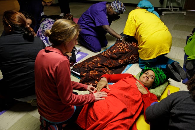 Women role play on how to comfort expectant mothers through touch during a doula workshop in Milwaukee in 2014. The doula training was aimed at creating culturally competent doulas to serve African-American and low-income women through childbirth.