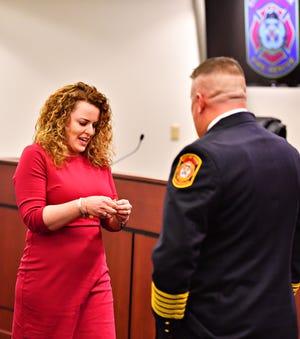 Jess Deardorff, left, prepares to pin her husband, York City Fire Chief Chad Deardorff during his swearing-in ceremony at York City Hall in York City, Friday, March 8, 2019. Dawn J. Sagert photo