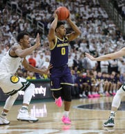 Michigan guard David DeJulius passes Michigan State striker Xavier Tillman in the first half on Saturday, March 9, 2019 at the Breslin Center in East Lansing, Mich.