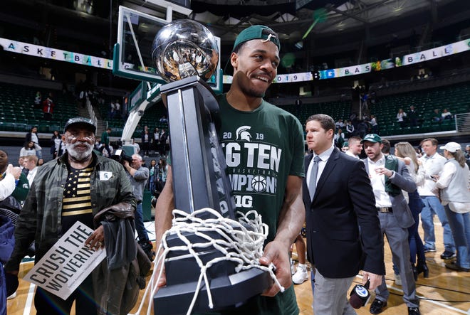 Michigan State's Xavier Tillman holds the Big Ten championship trophy after defeating Michigan on Saturday.