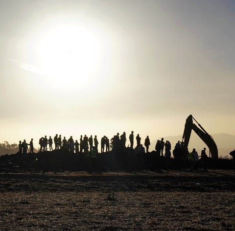 Rescue and recovery personnel use an earth mover...