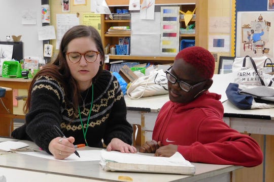 FSU graduate student Brie Medina, left, and Raa seventh-grader Chanel Thomas explore book-making techniques.