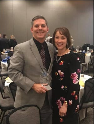 Tom Burton, superintendent of Princeton City Schools, poses for a photo with his wife, France Burton, after accepting the 2018 Business Person of the Year award at the Champions of Commerce Celebration Feb. 21, 2019.