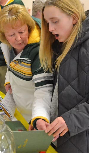 Hayden Beekman, right, appears surprised as she and her grandmother Nancy Gering look over the 1910 Oconto HIgh School yearbook, one of several old volumes on display courtesy of Farnsworth Public Library at the City of Oconto Sesquicentennial Celebration Kickoff Reception on March 11.