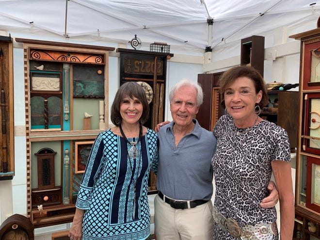 Joan Earnhart, left, George Paxton and Paulette Visceglia at Earnhart’s booth
at the 68th annual Under the Oaks art show March 10.