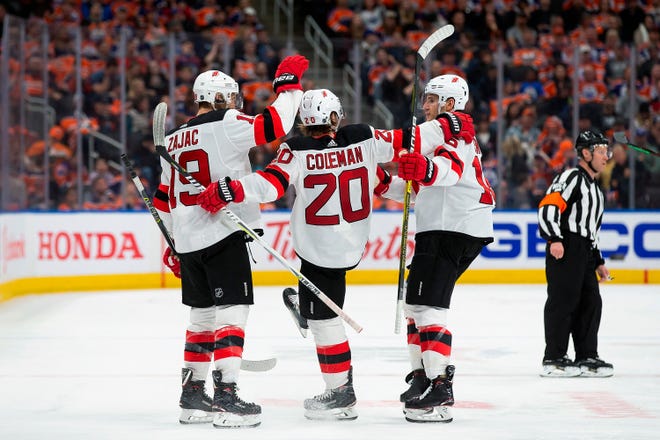 New Jersey Devils' Travis Zajac (19), Blake Coleman (20) and Steven Santini (16) celebrate Coleman's goal against the Edmonton Oilers during the third period of an NHL hockey game Wednesday, March 13, 2019, in Edmonton, Alberta. (Codie McLachlan/The Canadian Press via AP)