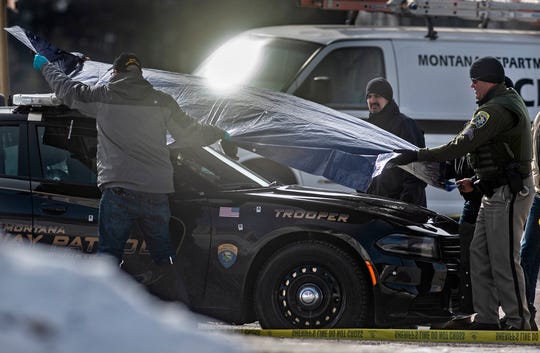 Police officers cover the car of Montana State Soldier Wade Palmer at the scene of the shooting near Bar Evaro on Friday morning.