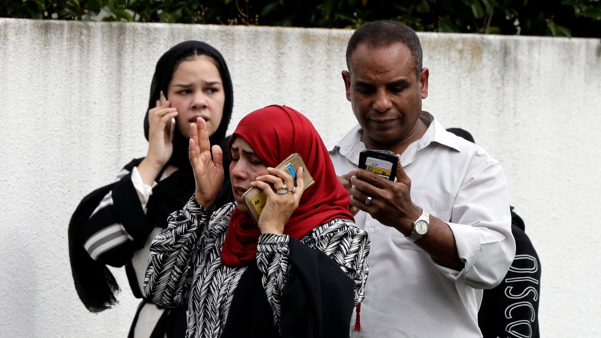 People wait outside a mosque in Christchurch, New Zealand, on Friday, following a reported mass shooting.