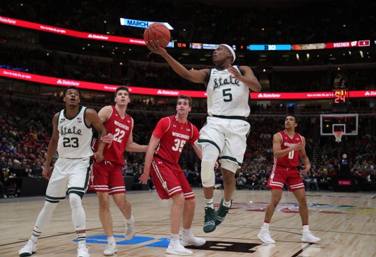 Michigan guard, Cassiuis Winston, scores against the Wisconsin defensemen in the semifinal semi-final of the Big Ten tournament on Saturday, March 16, 2019, at the United Center in Chicago.