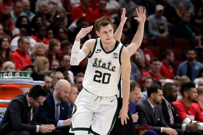 Michigan State's Matt McQuaid reacts after shooting a 3-point basket in the first half of the game against Wisconsin.