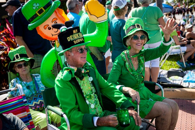 Dave and Susie Walsh wave to parade participants while they sit with their blow up Paddy during the Naples St. Patrick's Day Parade downtown on Saturday, March 16, 2019.