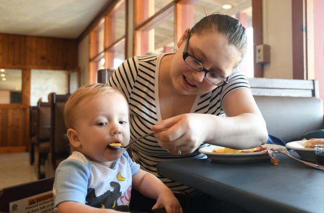 Mama K's Cafe regular Elizabeth Whitlock feeds her one-year-old son, James, scrambled eggs during the diner's soft reopening on Saturday morning. The restaunt reopens to the public 7 a.m. Monday at the former Livestock Cafe building.