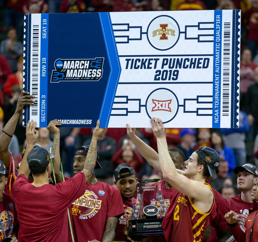 Iowa State players hold up a March Madness tournament ticket after the Big 12 championship game.