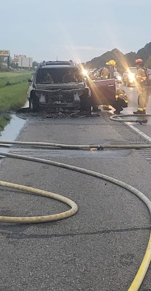 Firefighters extinguish Alfrelisha Thibeaux's car, which caught fire on the side of Interstate 10. Connor Manuel pulled over to help and signaled for her to get out of the car before it went up in flames.