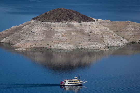The Desert Princess, a three-level paddle-wheeler, cruises past Rock Island, March 17, 2019, in the Lake Mead National Recreation Area near the Arizona/Nevada border. A high-water mark or 