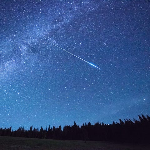 A meteor streaks over Yellowstone Park.