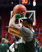 Michigan State forward Nick Ward, wearing a protective brace on his left hand, takes a shot during practice