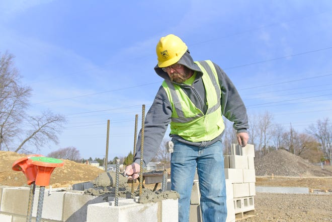 Josh Holland, of Ashland, lays mortar Wednesday morning before setting block that will form an elevator shaft at the new UH Samaritan Richland Health Center location in Mansfield. 