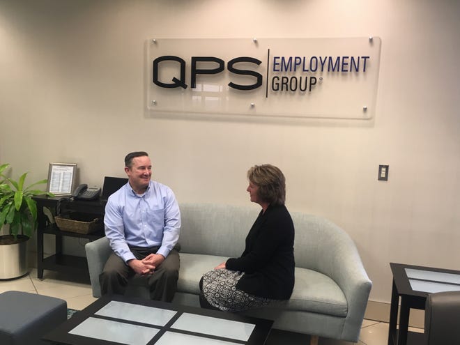 John Boettcher, workers' compensation manager for QPS Employment Group, chats with Cheryl Datka, executive administrative manager, at the  Brookfield office of QPS. The company  has been honored as a Top Workplace for 10 consecutive years.