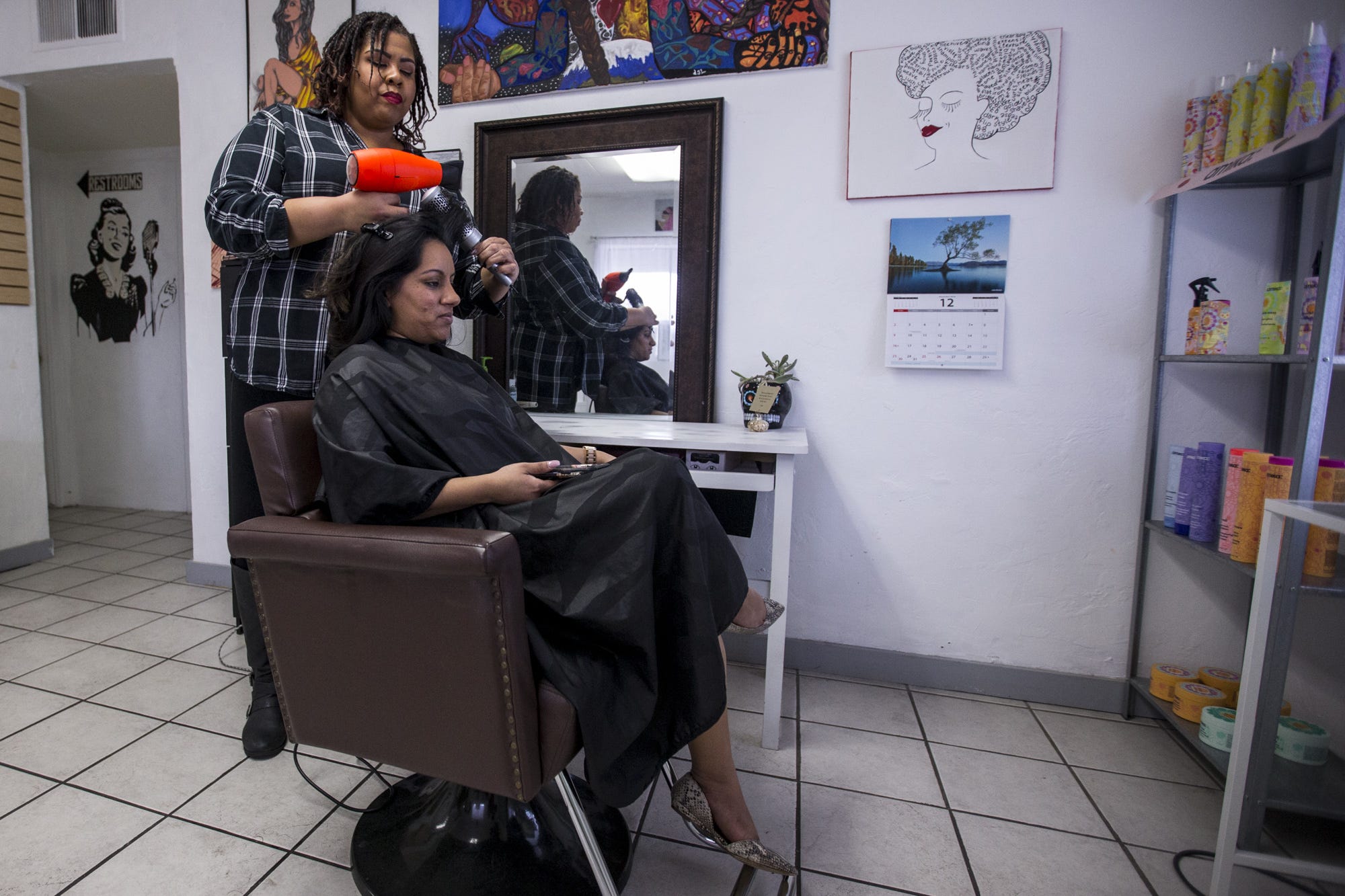 Christina Lopez works on Sarah Parks' hair at Lopez's salon on Feb. 21, 2019, in Phoenix.