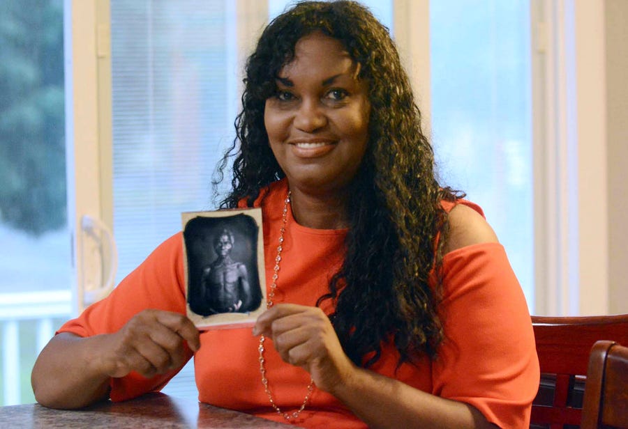 In this July 17, 2018, photo, Tamara Lanier holds an 1850 photograph of Renty, a South Carolina slave who Lanier said is her family's patriarch, at her home in Norwich, Connecticut.