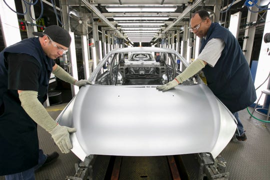 Two UAW workers at GM's Orion Assembly plant where GM builds its Bolt EV and the self-driving test cars.