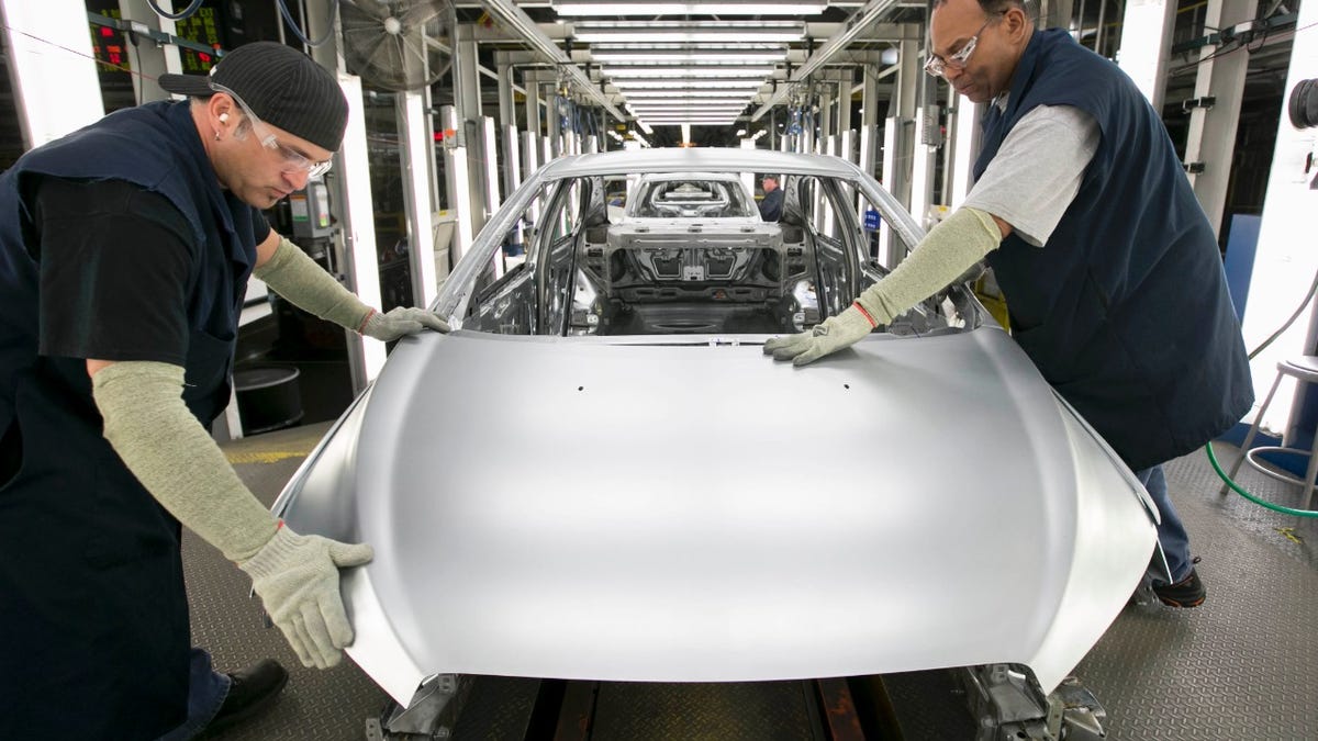 Two UAW workers at GM's Orion Assembly plant where GM builds its Bolt EV and the self-driving test cars.