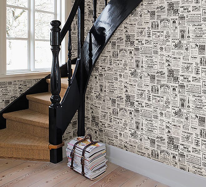 Wallpaper with a newspaper motif sets the tone in an entry.