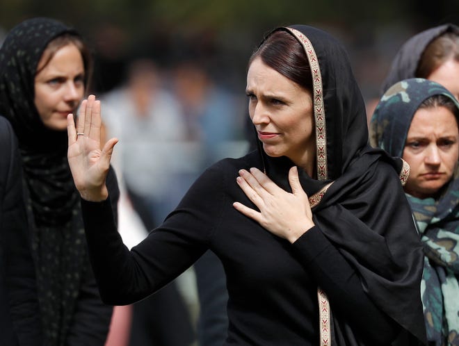 New Zealand Prime Minister Jacinda Ardern, center, waves as she leaves Friday prayers at Hagley Park in Christchurch, New Zealand, Friday, March 22, 2019. People across New Zealand are observing the Muslim call to prayer as the nation reflects on the moment one week ago when 50 people were slaughtered at two mosques. (AP Photo/Vincent Thian)